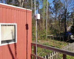 Completed gateway with satellite mount and 2-inch steel pole affixed to a plywood deck. Both data and 12 volts is transmitted over the ethernet cable.